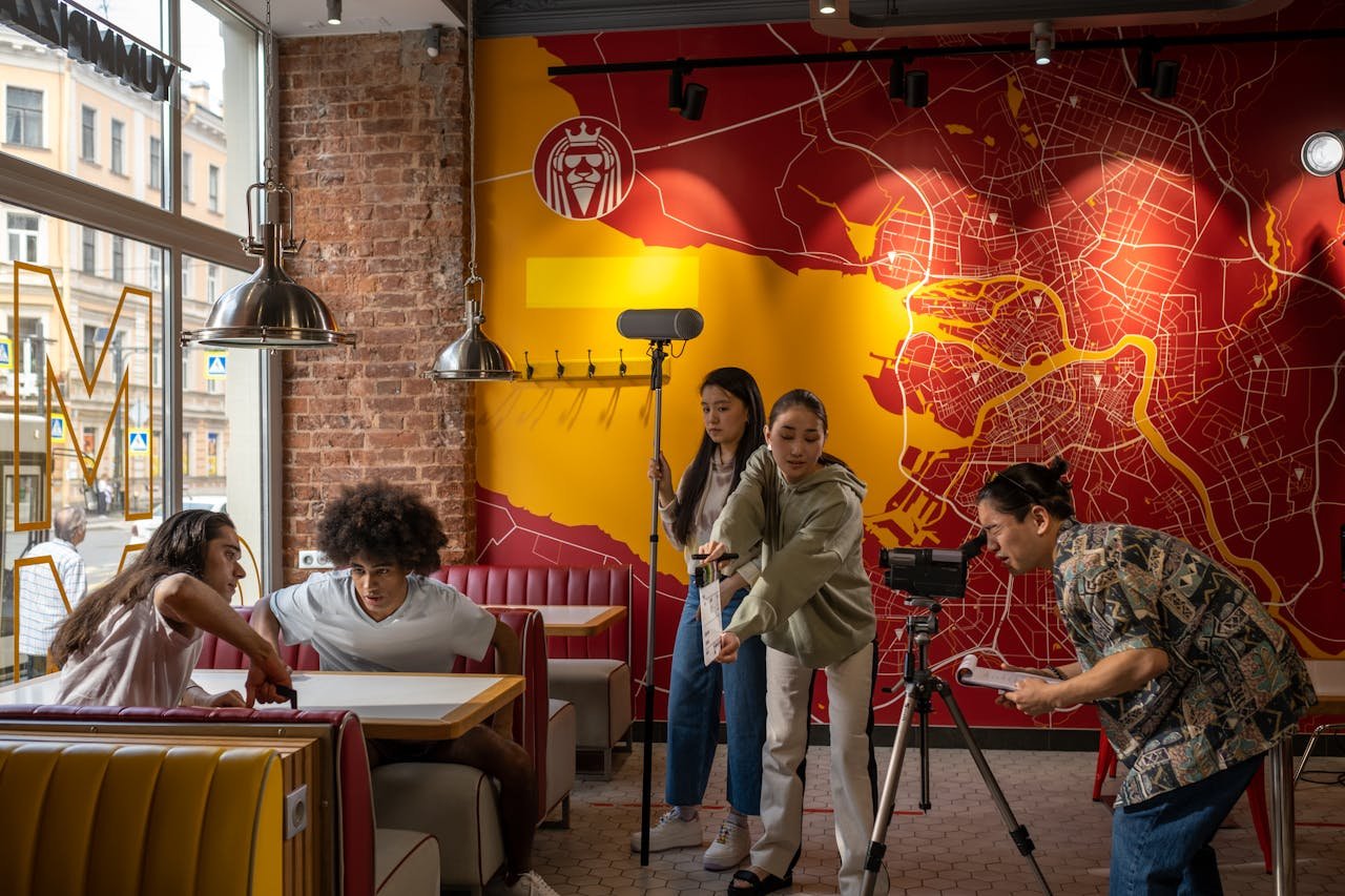 gallery-1 A diverse film crew operates in a trendy urban restaurant with a vibrant map mural.